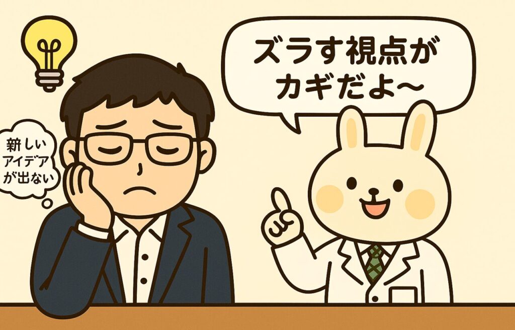 新しいアイデアが出ない…」と悩む表情のまなぶくん(スーツ姿の男性)に対して、白衣を着たウサギのキャラクター・みどりんが「ズラす視点がカギだよ〜」と優しくアドバイスしているイラスト。シンプルな背景で、ふきだし形式のセリフ付き。
